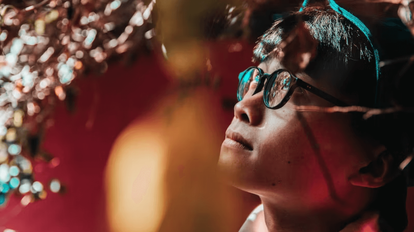 A woman wearing glasses and looking upward